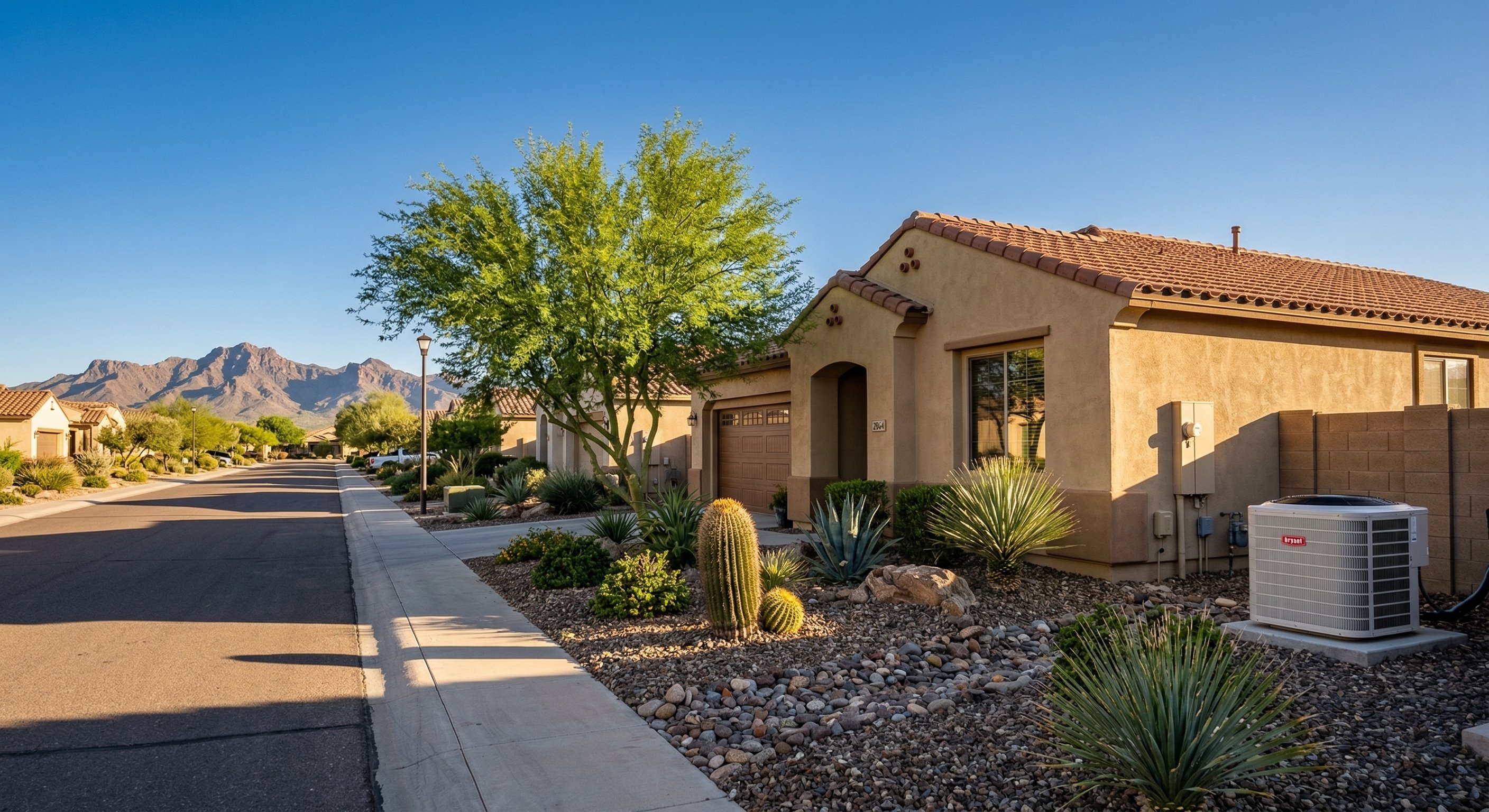 Goodyear AZ neighborhood with stucco homes and desert landscaping, AC condenser on side of home, Estrella Mountains in background