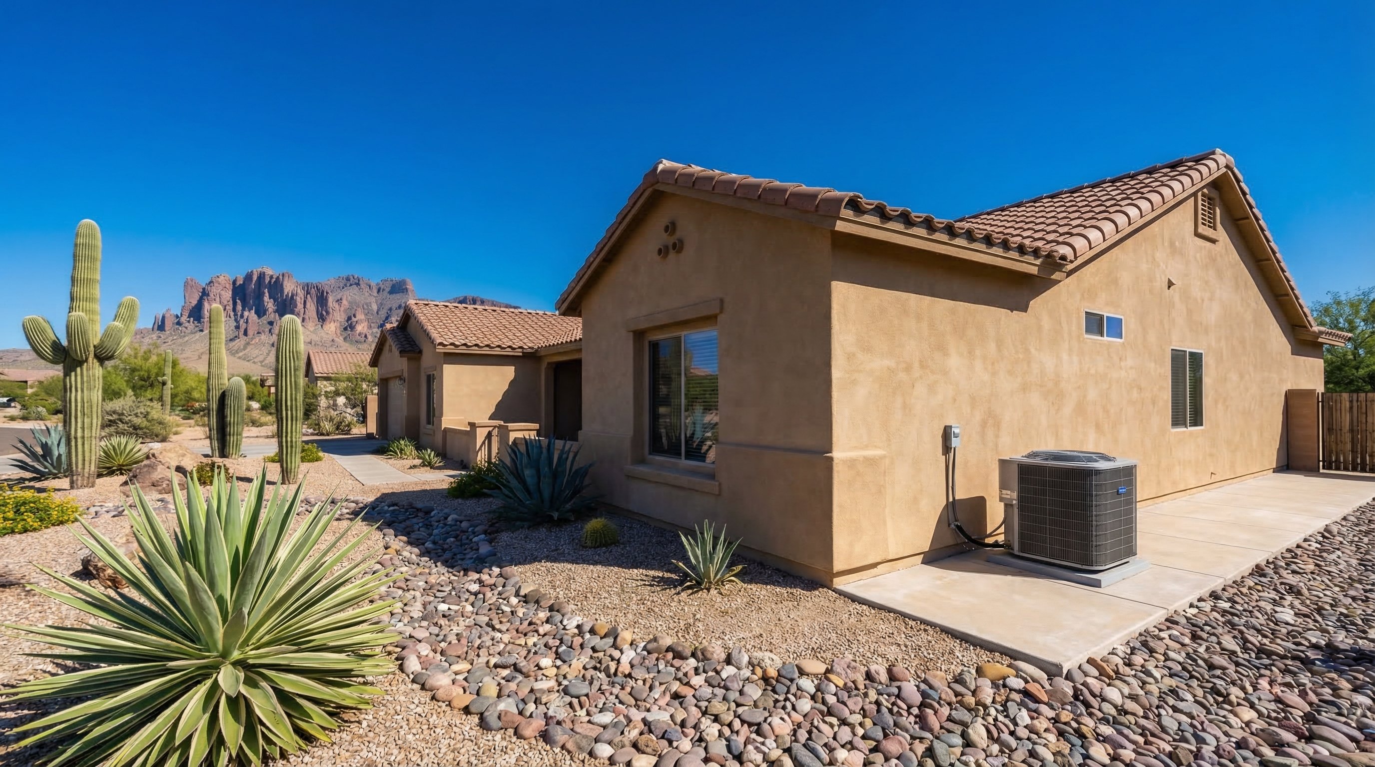 A properly placed AC condenser unit beside a stucco home in Apache Junction, AZ with desert landscaping and Superstition Mountains in the background