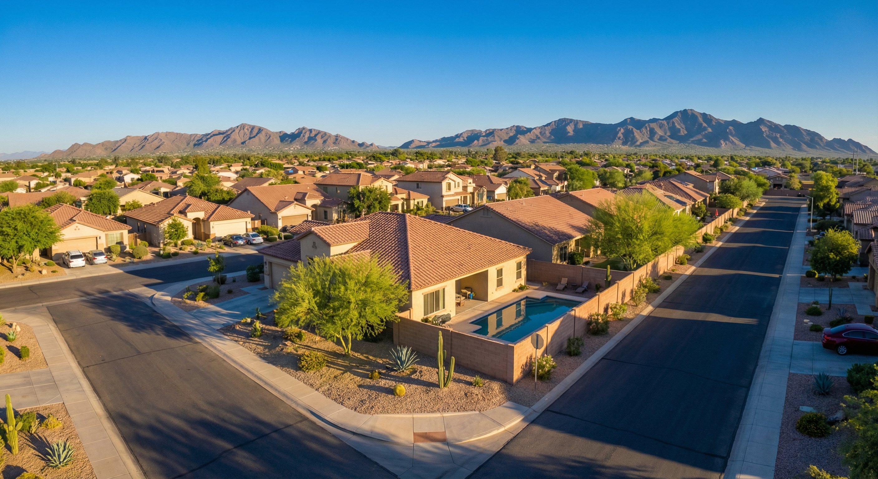Phoenix neighborhood aerial view showing tile roofs and desert landscaping in late afternoon summer light
